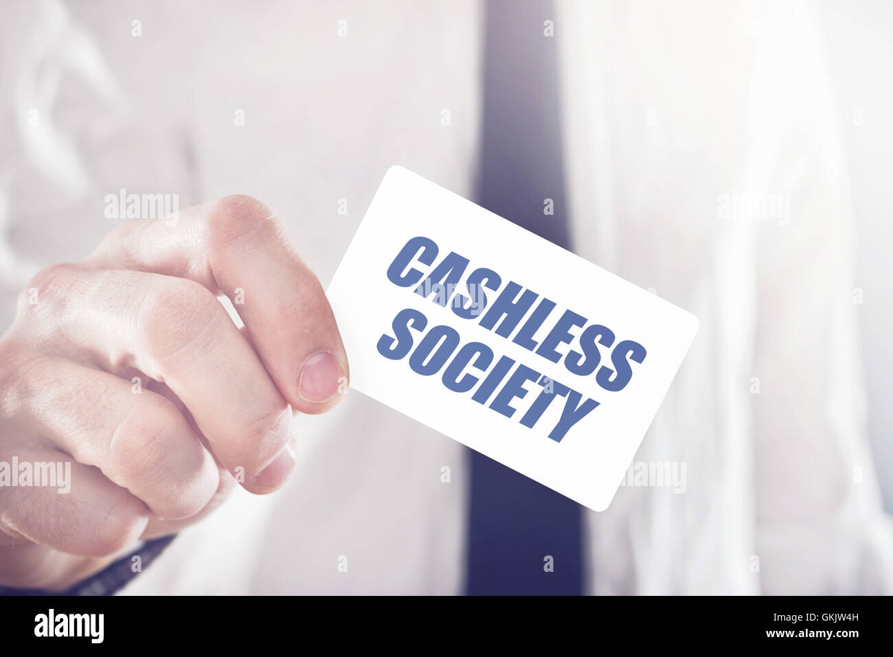 Businessman holding card with Cashless society title, concept of promoting mobile and electronic payments without cash money ban Stock Photo
