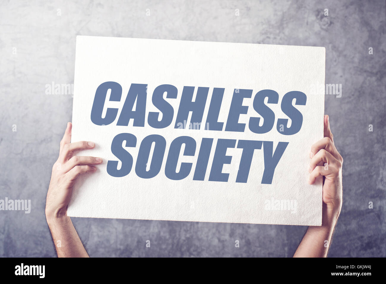 Hands holding banner with Cashless society title, concept of promoting mobile and electronic payments without cash money Stock Photo