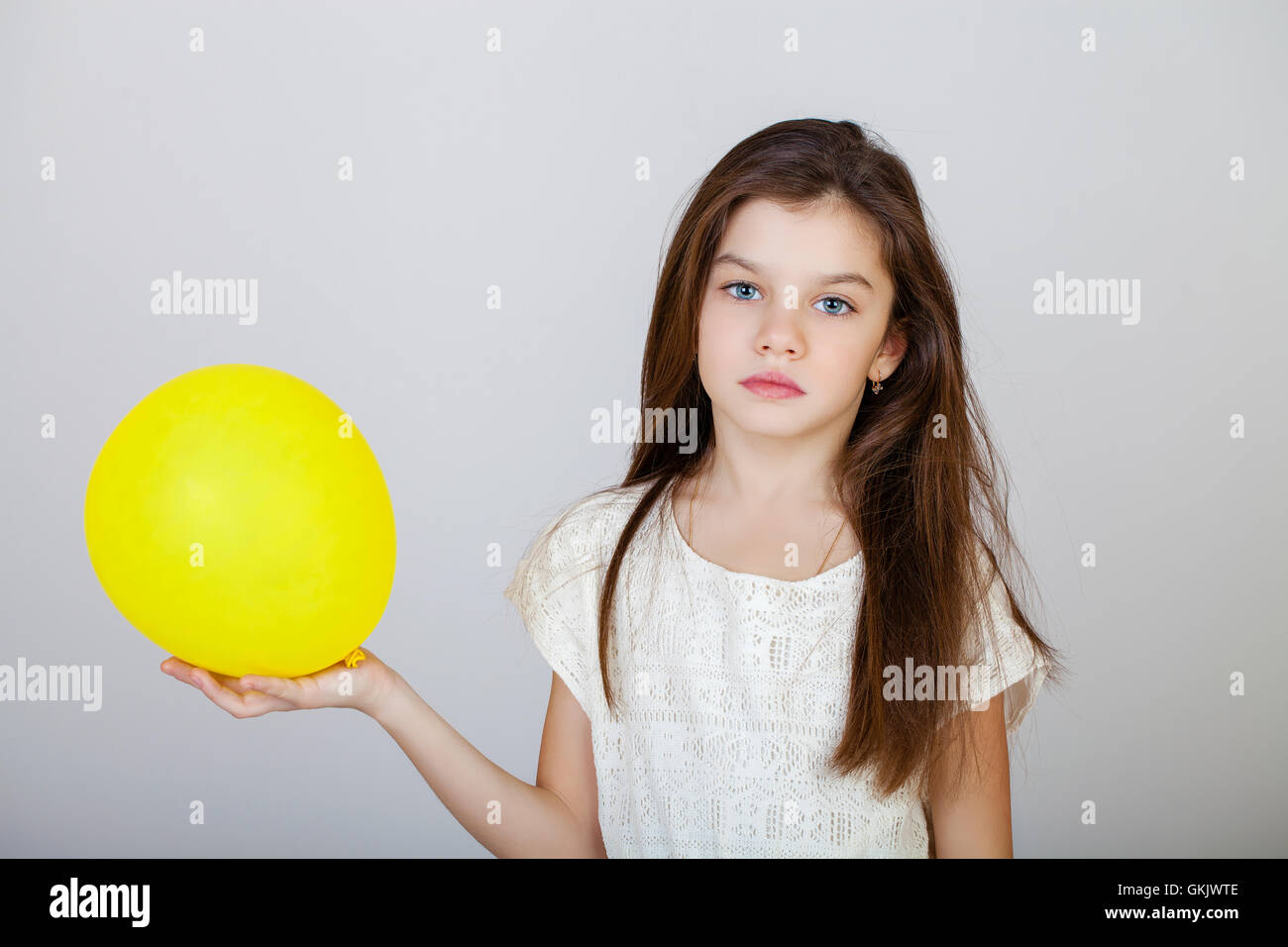 Portrait of a charming brunette little girl, isolated on gray background Stock Photo