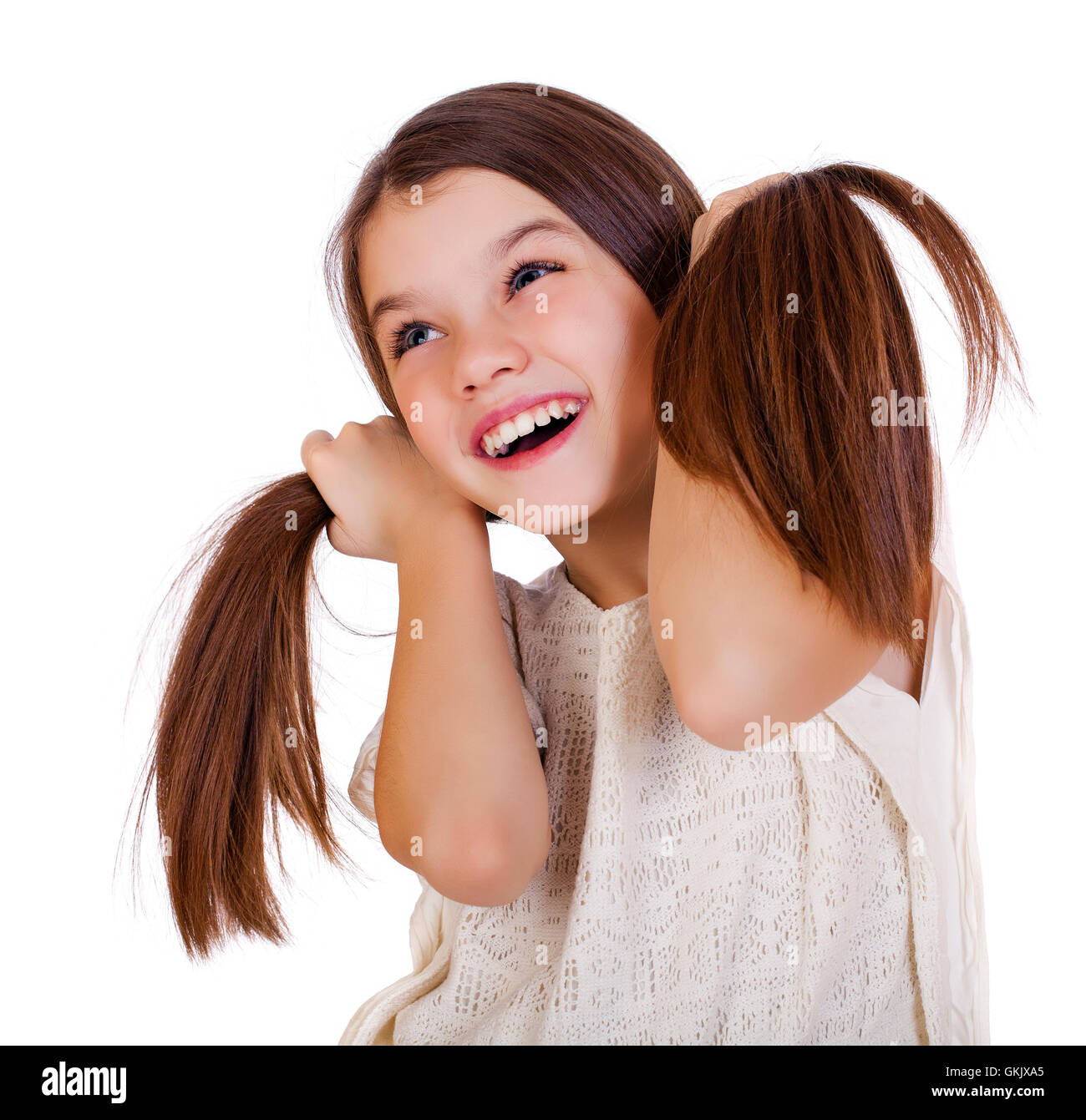 Portrait of a charming little girl smiling at camera, isolated on white ...