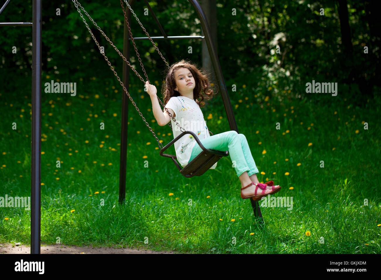 Happy Little girl on a swing in the summer park Stock Photo - Alamy