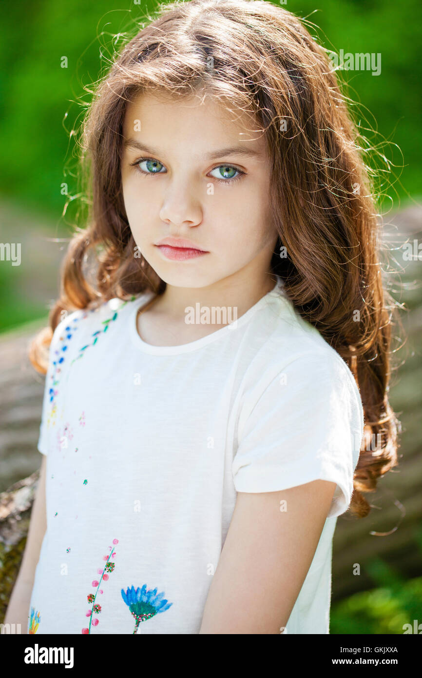 Portrait of a beautiful young little girl on the background of summer ...