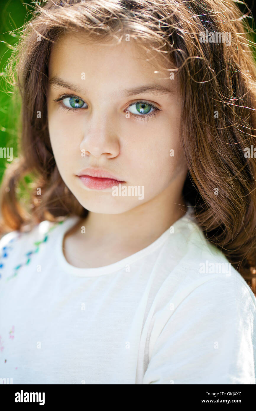 Portrait of a beautiful young little girl on the background of summer ...