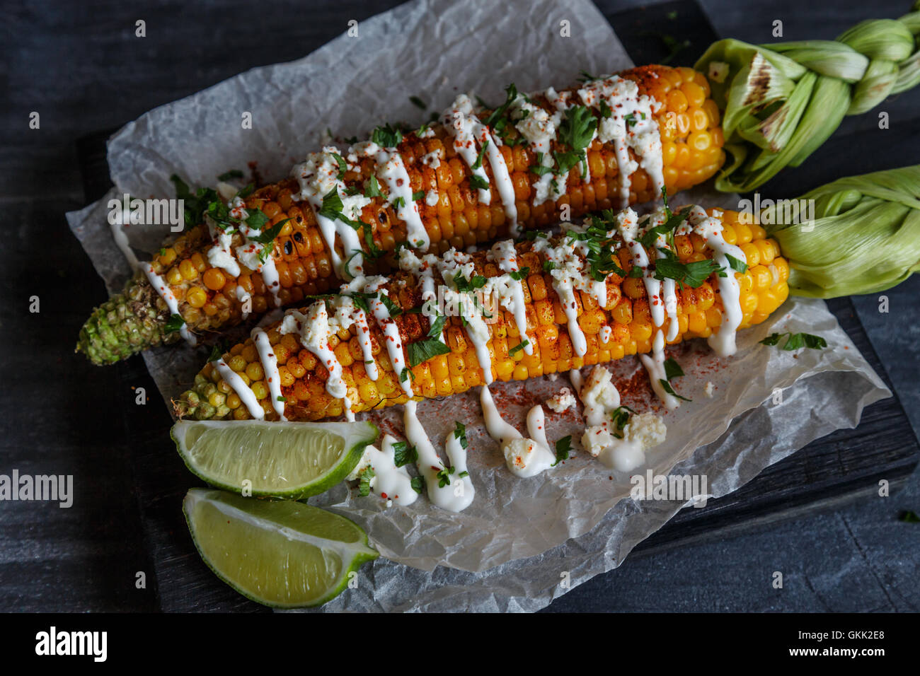 Elote or Mexican grilled corn on the cob served with cotija cheese and Elote or Mexican grilled corn on the cob served with cotija cheese and