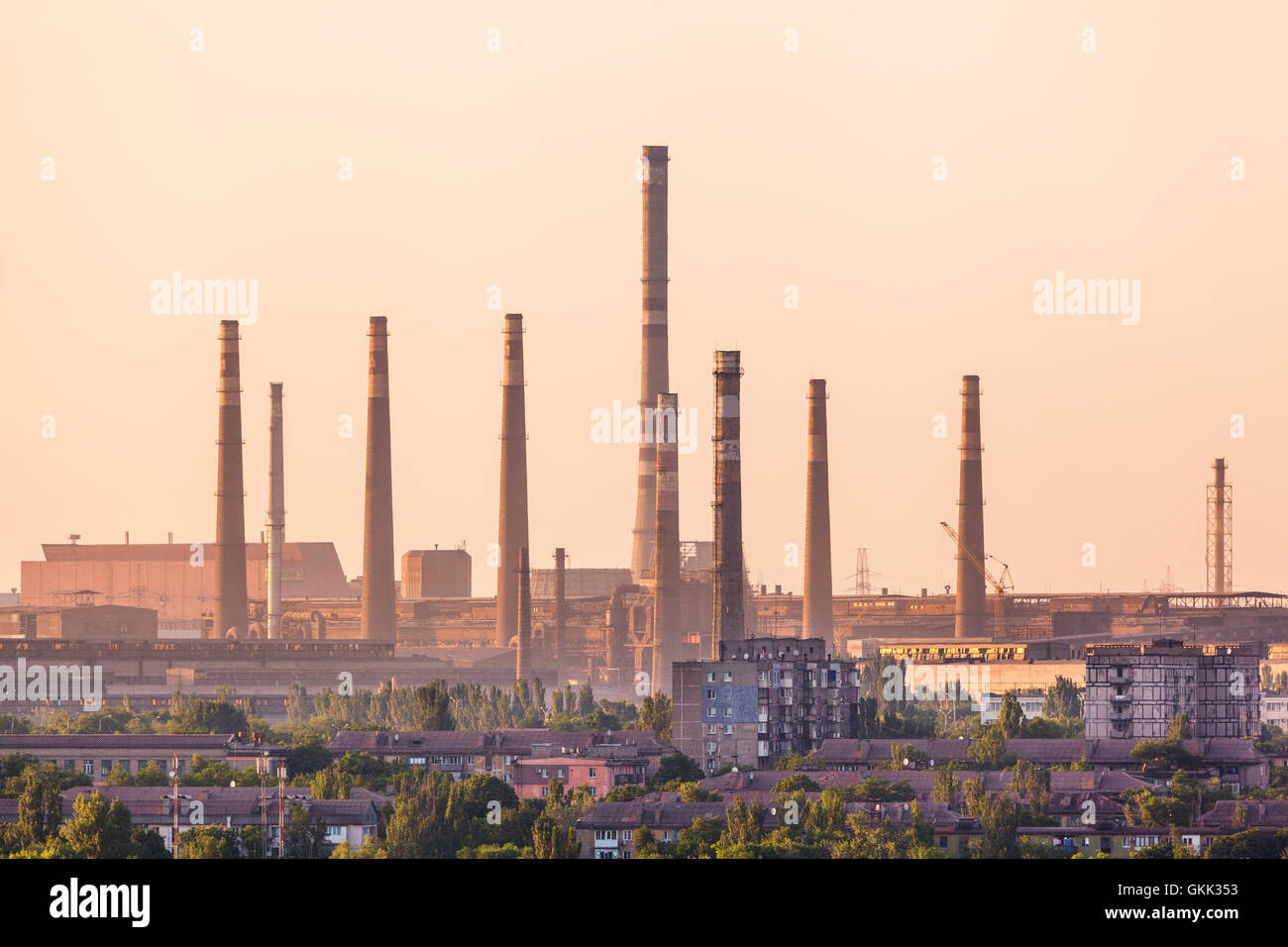 Industrial landscape. Steel factory at sunset. Pipes with smoke. Metallurgical plant. steelworks, iron works. Heavy industry in  Stock Photo