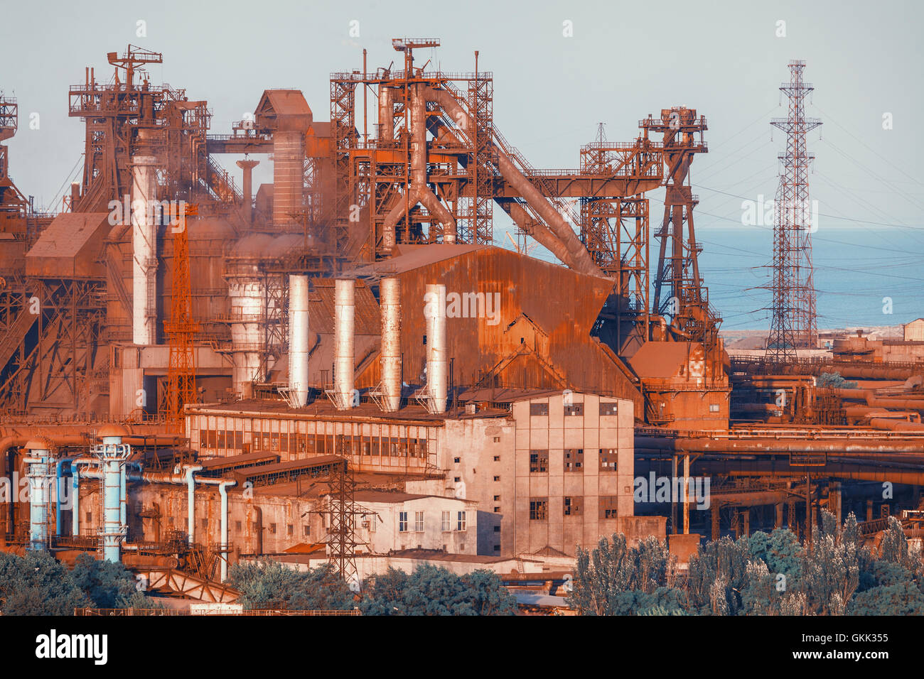 Industrial buildings . Steel factory at sunset. Pipes with smoke. Metallurgical plant. steelworks, iron works. Heavy industry in Stock Photo