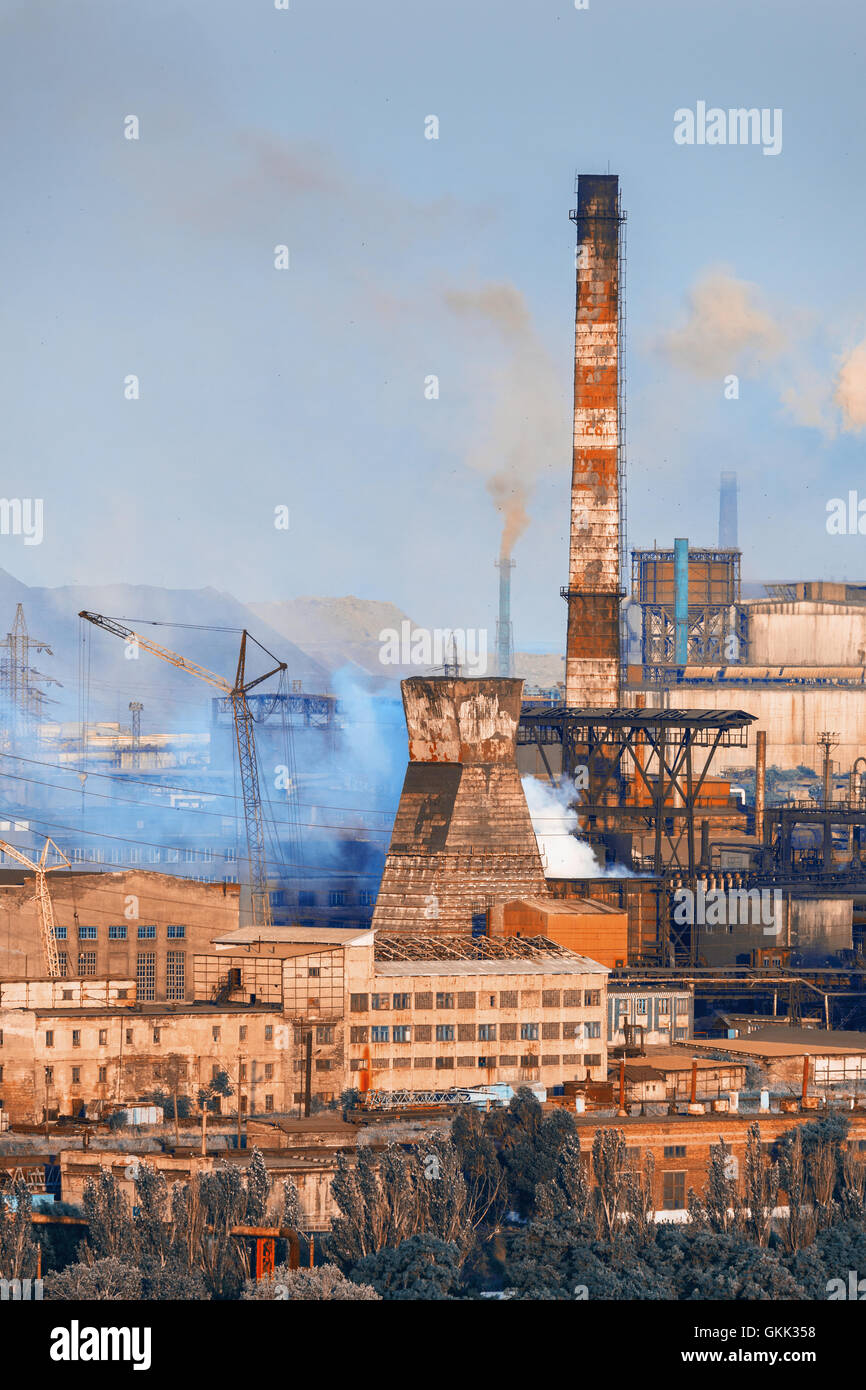 Industrial landscape. Steel factory at sunset. Pipes with smoke. Metallurgical plant. steelworks, iron works. Heavy industry in  Stock Photo
