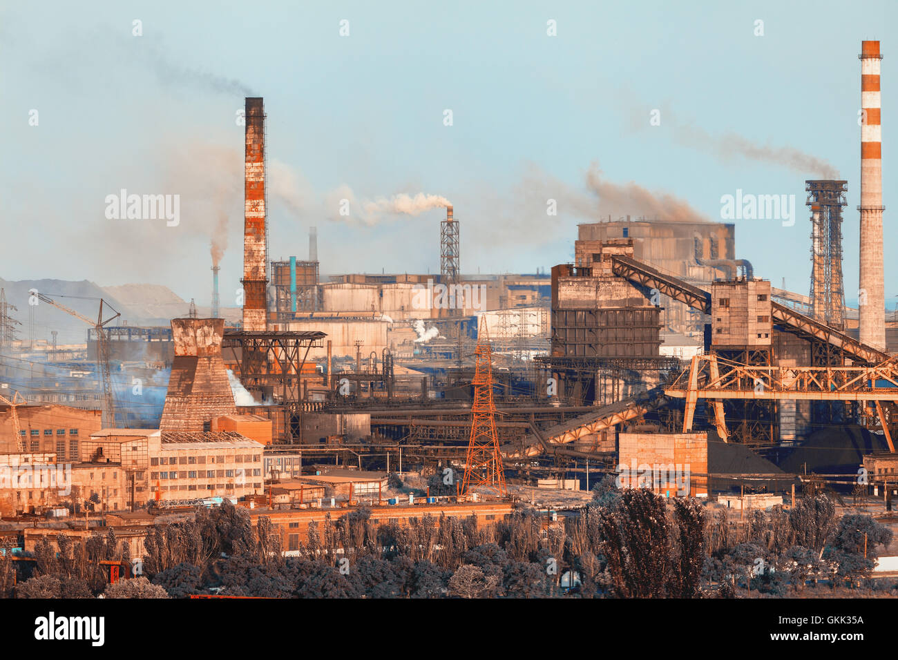 Metallurgical plant. Industrial landscape. Steel factory at sunset. Pipes with smoke. steelworks, iron works. Heavy industry in  Stock Photo