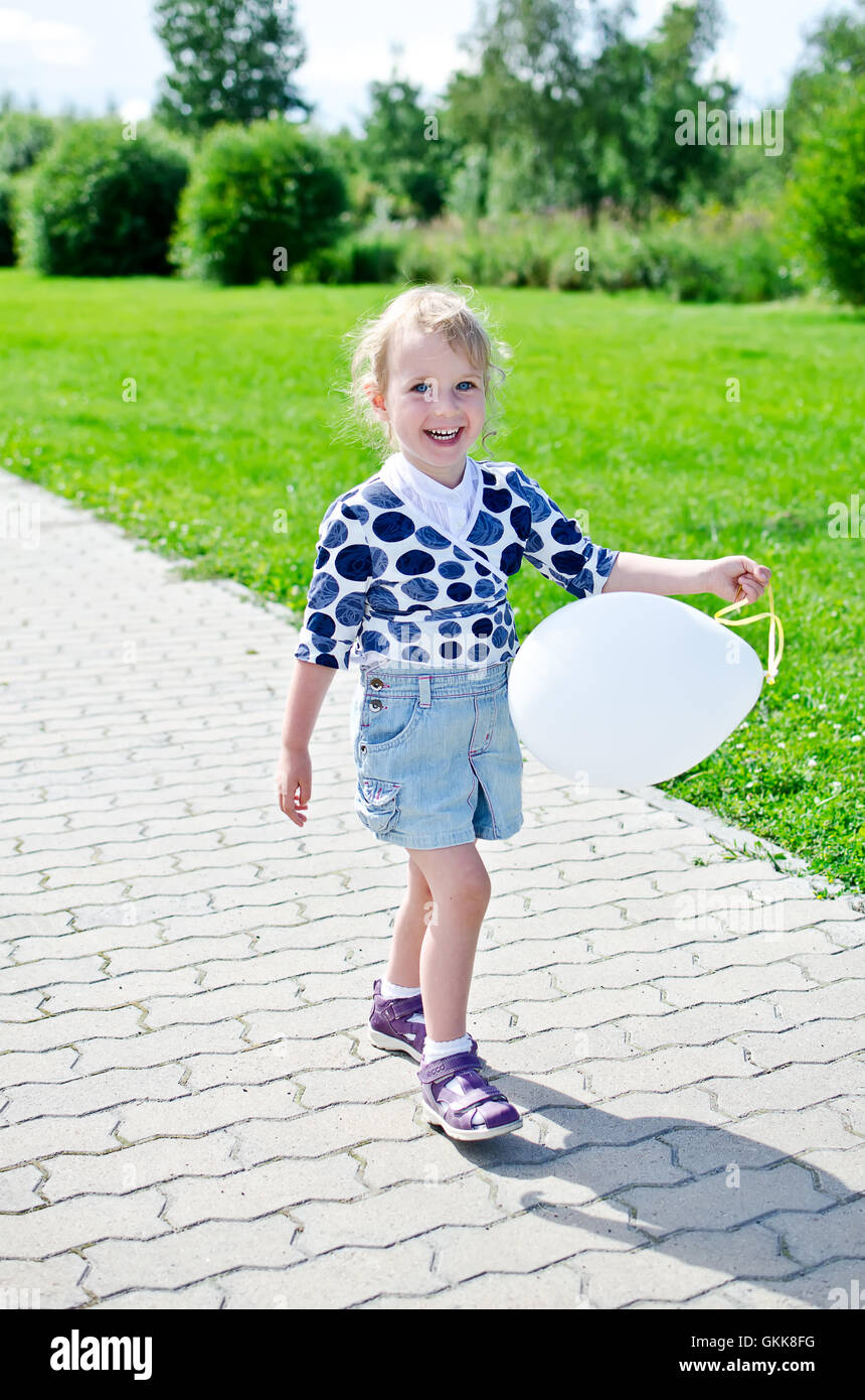 Smiling little girl with balloon in the park Stock Photo - Alamy