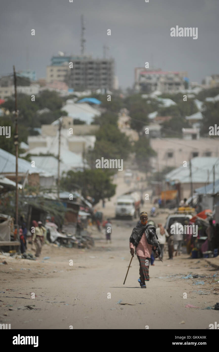 A man walks up a hill in front of Bakara Market in the capital of Mogadishu, Somalia, on October 2. Two decades after the infamous Battle of Mogadishu, in which the United States lost eighteen soldiers during a mission into Bakara Market, Somalia is finally showing signs of recovery from its more than two decades of civil war. Nowhere is this more evident than in Mogadishu's Bakara Market, where business is thriving and new shops continue to be opened everyday. AU UN IST PHOTO / TOBIN JONES. Stock Photo