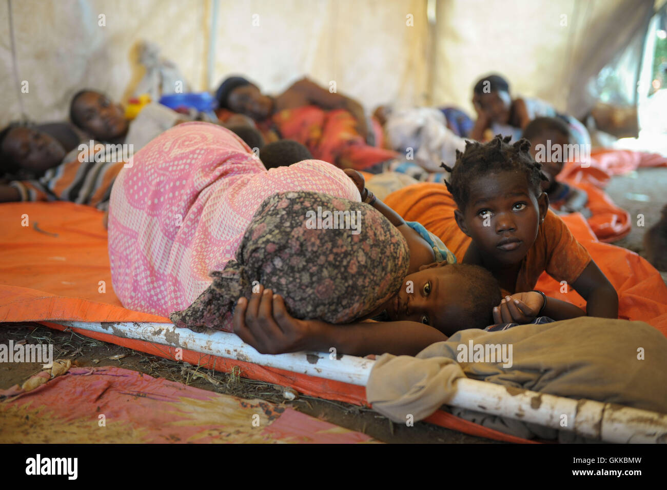 Women and children seek shelter at a temporary AMISOM medical camp near Jowhar on November 12, following flooding and clan conflict that displaced thousands. More continue to arrive daily. AMISOM Photo. Stock Photo