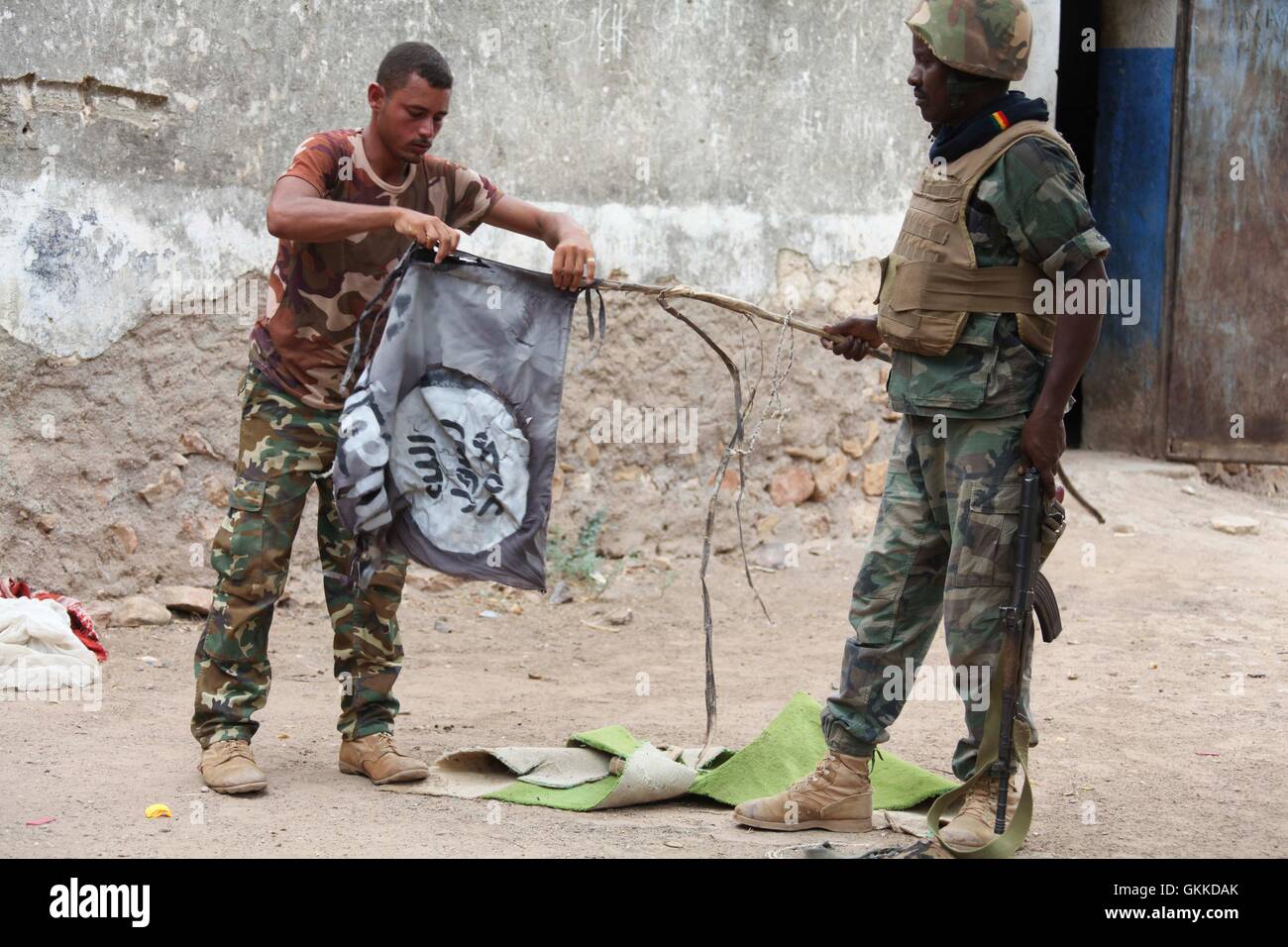 Djiboutian soldiers destroy an al Shabaab flag after the town of Bula Burde was liberated by AMISOM forces on 16th March 2014. AU UN IST PHOTO / Ilyas A. Abukar Stock Photo