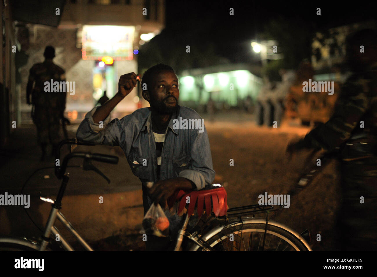 A Somali man smokes a cigarette while Ethiopian soldiers, as part of the African Union Mission in Somalia, conduct a night patrol through the city of Baidoa, Somalia, on June 22. AMISOM Photo / Tobin Jones Stock Photo