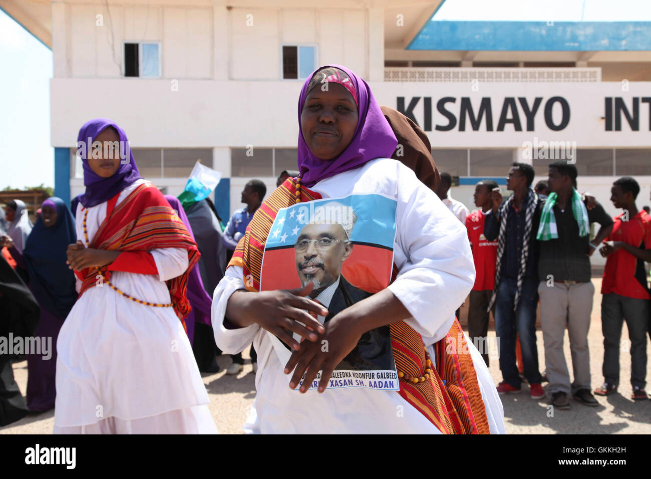 A woman holding a portrait of ISWA president Sharif Hassan Sheikh Adan ...