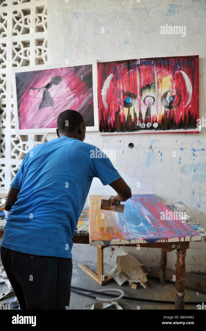 A Somali artist, Adan Farah Afey, paints at the Centre for Research and Dialogue (CRD) art studio in the Wadajir District of the Somali capital Mogadishu on April 26, 2015. Many Somali artists are now able to practice their art, educating the masses on social issues, promoting peace and advocating for good governance and unity, among other issues.  Mogadishu and most parts areas of Somalia are now enjoying the longest period of peace in years after sustained military operations by the Somali National Army (SNA) backed by African Union Mission in Somalia (AMISOM) forced Al shabab to retreat fro Stock Photo