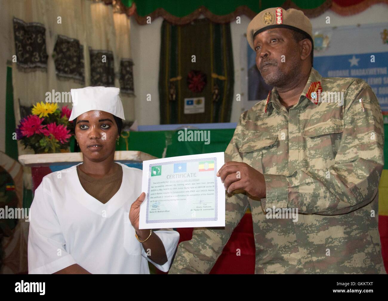 SNA Sector Three Commander, Genaral Ibrahim Adan Yarrow, hands over a certificate  to mark the completion of a training course for nurses in Baidoa, Somalia, on May 24. AMISOM Photo Stock Photo