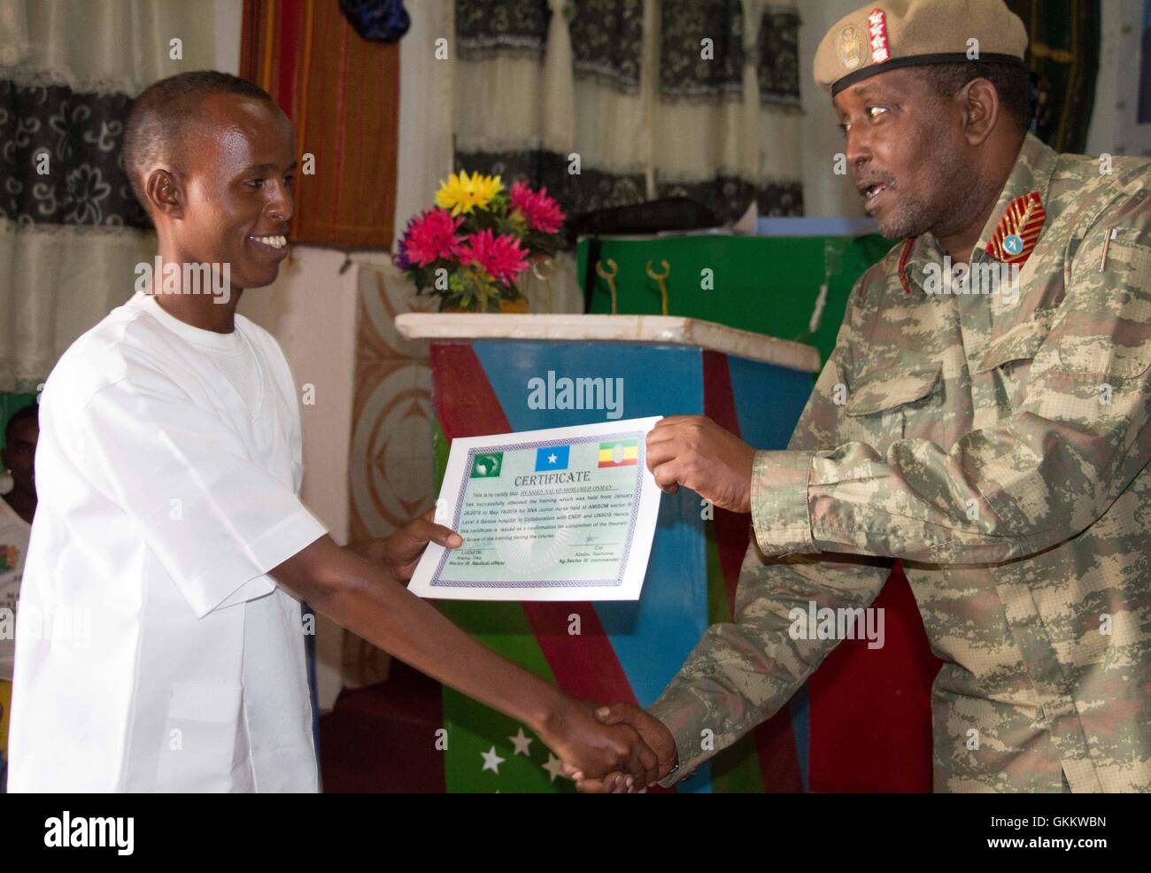 SNA Sector Three Commander, Genaral Ibrahim Adan Yarrow, hands over a certificate  to mark the completion of a training course for nurses in Baidoa, Somalia, on May 24. AMISOM Photo Stock Photo