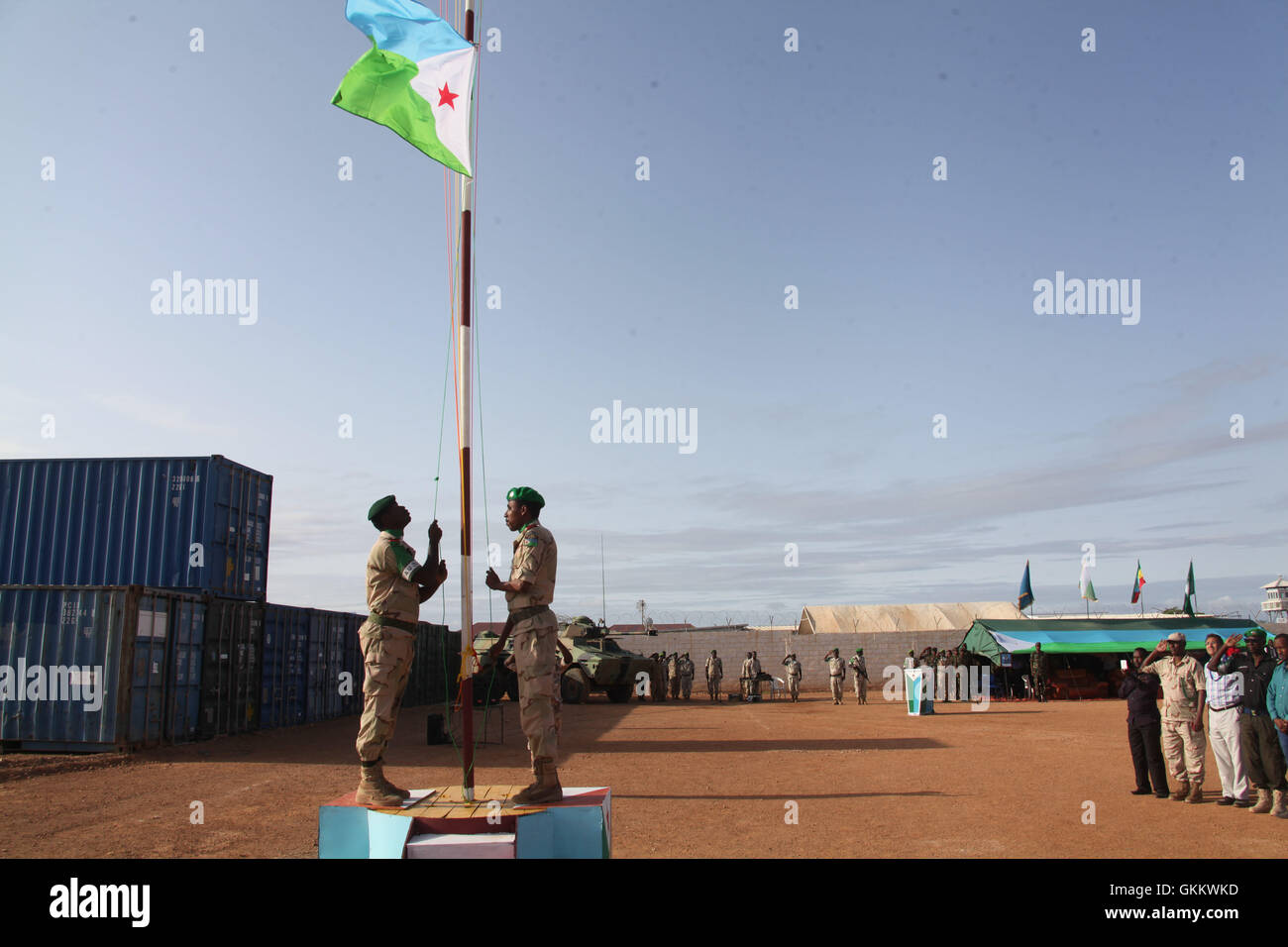 Djiboutian soldiers serving under  the African Union Mission in Somalia (AMISOM) hoist the Djibouti flag  during a ceremony to mark 39th anniversary of Djibouti independent day in Beletweyne on June 27, 2016. AMISOM Photo / Ismail Hassan Stock Photo