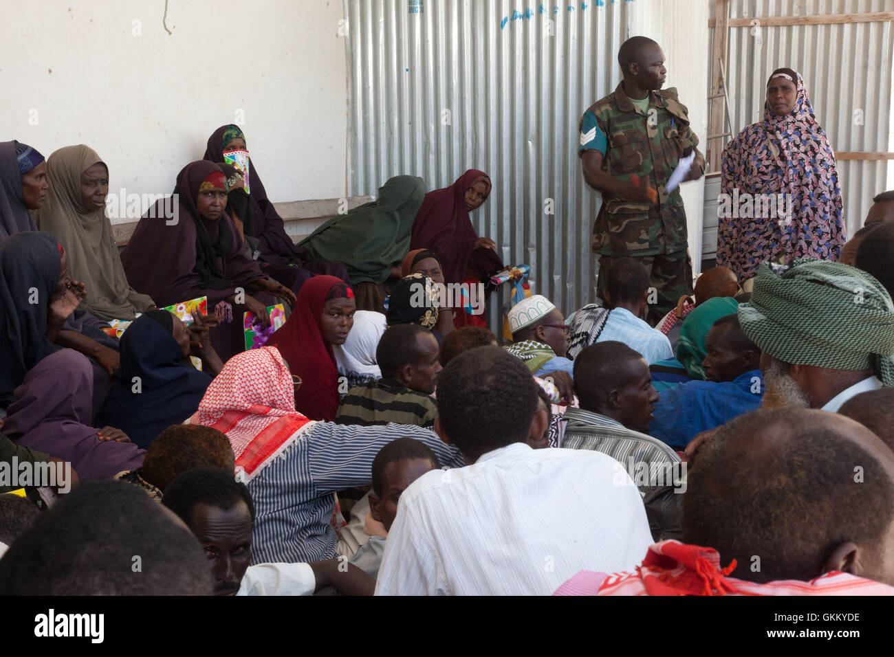10/09/11, Mogadishu, Somalia - An AMISOM doctor with the aid of a local interpreter provides health advice to assembled Somalians Stock Photo