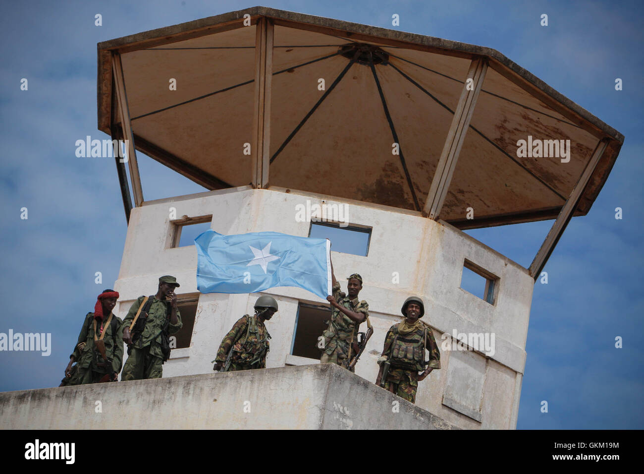 SOMALIA, Kismayo: In a handout photograph released by the African Union-United Nations Information Support Team 02 October, members of the Somali National Army and the government-allied Ras Kimboni militia display the Somali national flag from the former control tower of Kismayo Airport while they celebrate it's capture after Kenyan AMISOM troops moved into and through Kismayo, the hitherto last major urban stronghold of the Al-Qaeda-affiliated extremist group Al Shabaab, on their way to the airport without a shot being fired following a two-month operation to liberate towns and villages acros Stock Photo