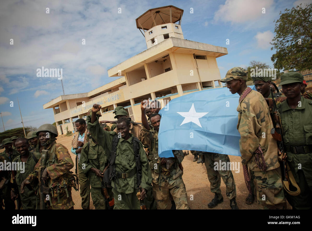 SOMALIA, Kismayo: In a handout photograph released by the African Union-United Nations Information Support Team 02 October, members of the Somali National Army and the government-allied Ras Kimboni militia display the Somali national flag while they celebrate the capture of Kismayo Airport after Kenyan AMISOM troops moved into and through Kismayo, the hitherto last major urban stronghold of the Al-Qaeda-affiliated extremist group Al Shabaab, on their way to the airport without a shot being fired following a two-month operation to liberate towns and villages across southern Somalia and Kismayo  Stock Photo