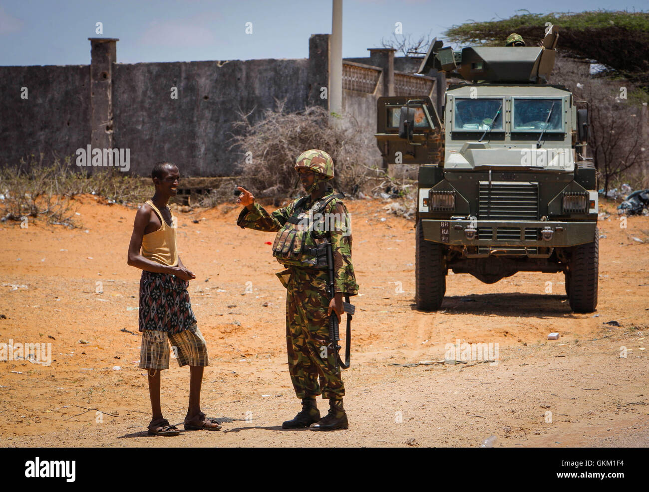 SOMALIA, Kismayo: In a handout photograph taken 05 October and released by the African Union-United Nations Information Support Team 06 October, a soldier serving with the Kenyan Contingent of the African Union Mission in Somalia (AMISOM) gestures as he talks to a Somali man at the roadside in the southern Somali port city of Kismayo. The last bastion of the once feared Al-Qaeda-affiliated extremist group Al Shabaab, Kismayo fell after troops of the Somali National Army (SNA) and the pro-government Ras Kimboni Brigade supported by Kenyan AMISOM forces entered the port city on 02 October follow Stock Photo