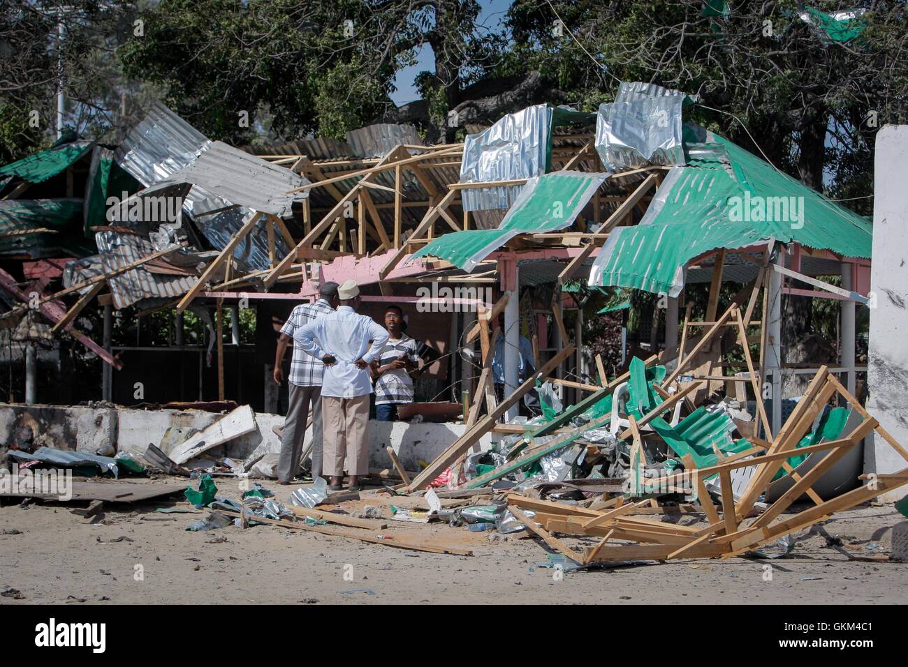 SOMALIA, Mogadishu: In a photograph taken and released 07 September 2013 by the African Union-United Nations Information Support Team, two men talk to workers clearing debris at the Village Restaurant after a double suicide attack by Al-Qaeda-affiliated extremist group Al Shabaab killed 18 people and injured dozens more at the popular Mogadishu eatery in the Somali capital. Speaking at the opening of a National Conference on Tackling Extremism in Somalia in the capital today, Presdient Hassan Sheikh Mohamud said that extremists no longer only attack government officials and foreign missions, b Stock Photo