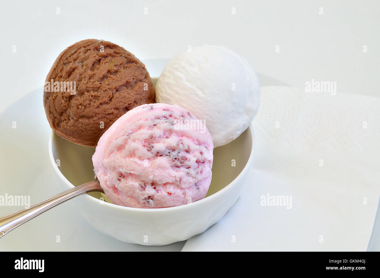 scoops of chocolate ice cream, vanilla ice cream and strawberry ice cream in a white bowl, close up, macro, horizontal Stock Photo