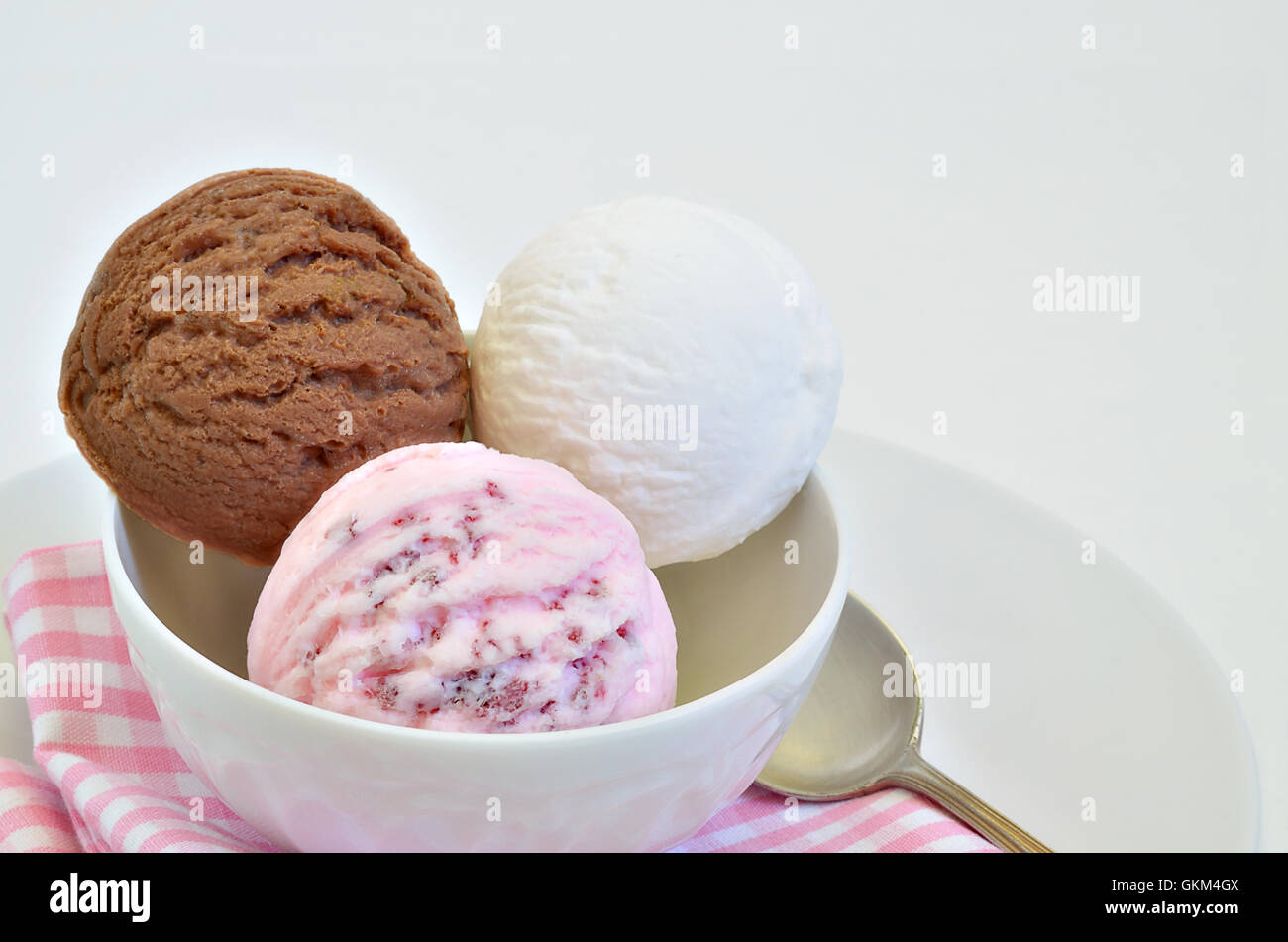 scoops of chocolate ice cream, vanilla ice cream and strawberry ice cream in a white bowl, close up, macro, horizontal Stock Photo