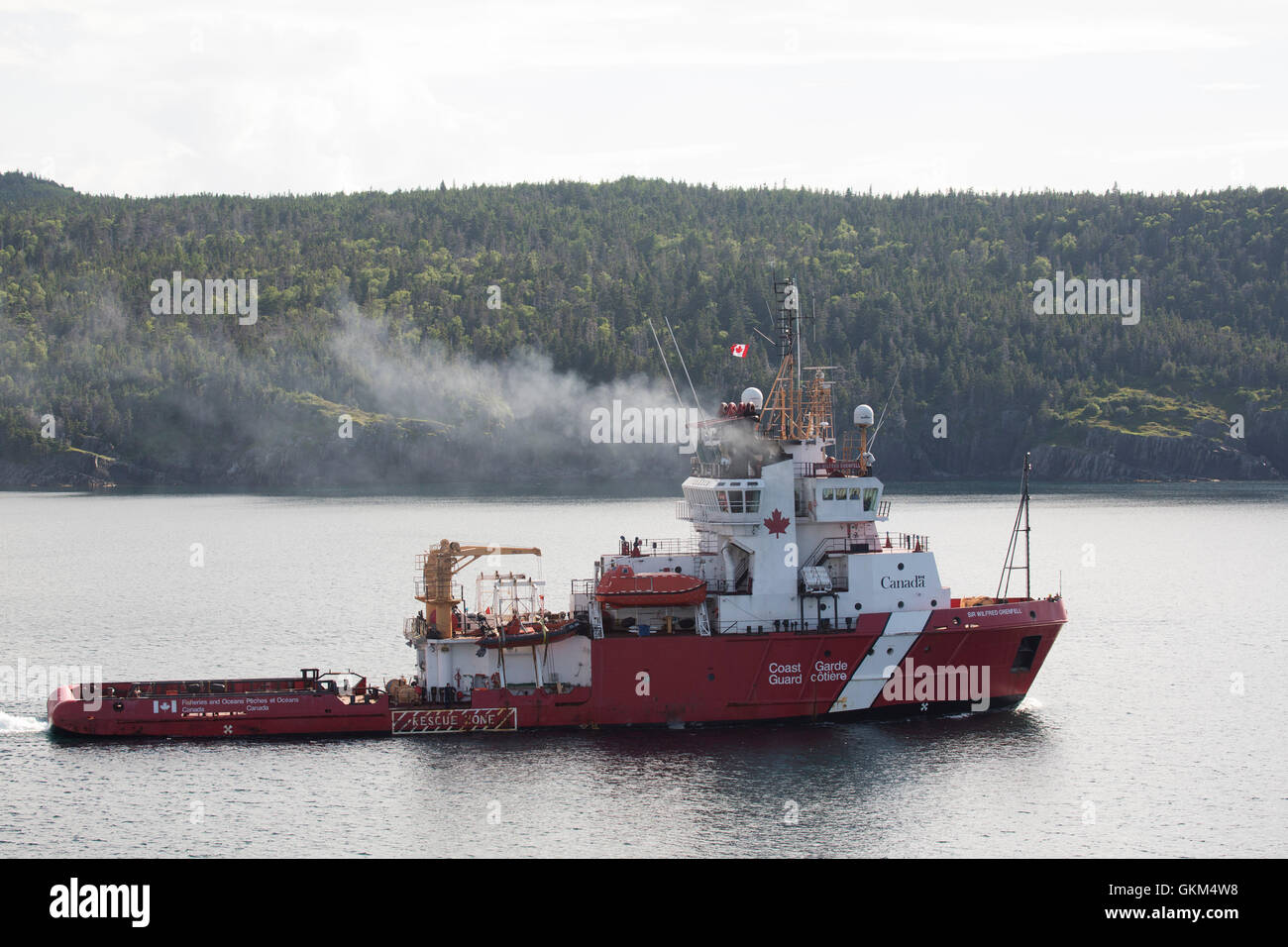 A Canadian Coast Guard ship off the coast of Newfoundland and Labrador, Canada. The ship has red and white livery. Stock Photo