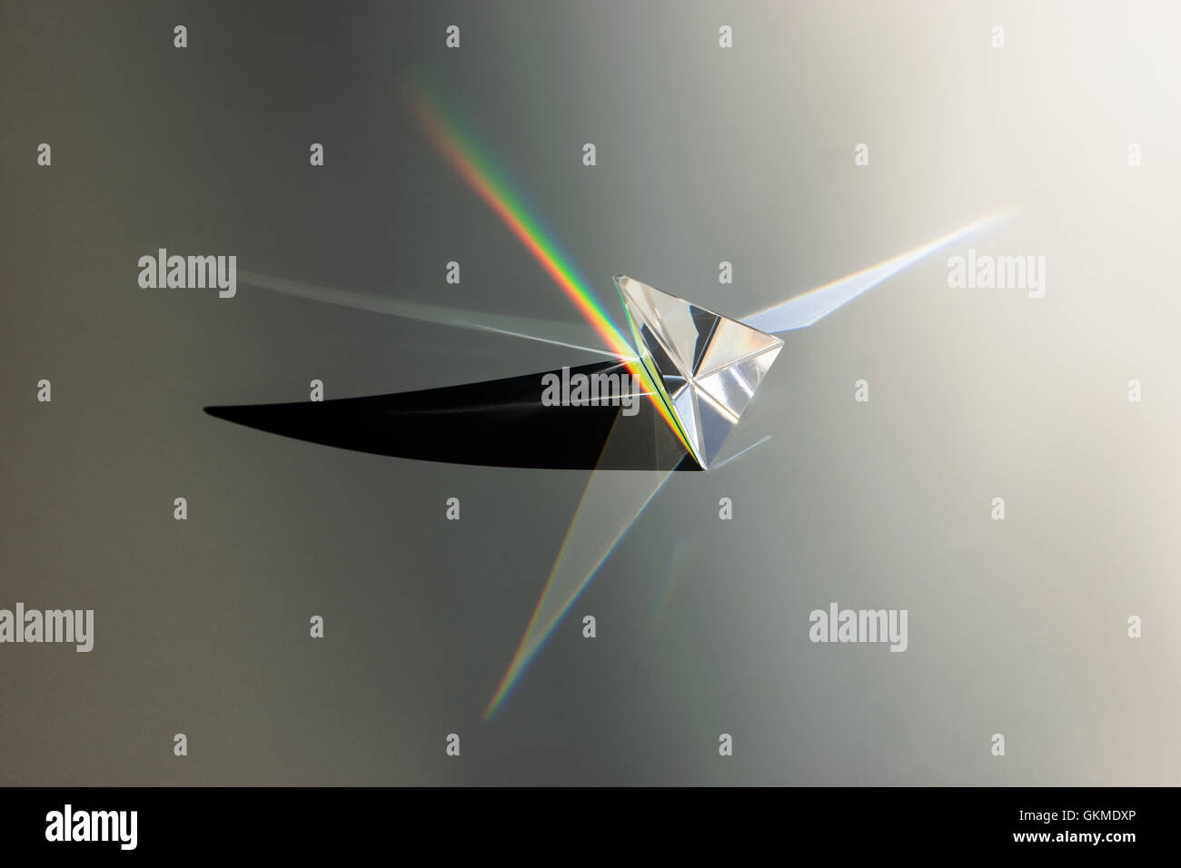 glass prism from above with rainbow beam and shadow Stock Photo