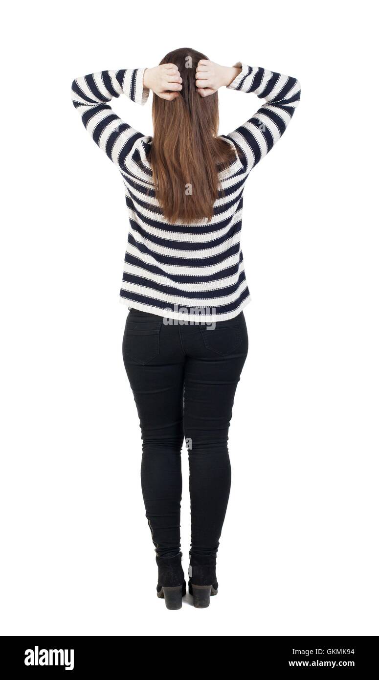 Back view of shocked woman in jeans. girl hid his eyes behind his hands. Rear view people collection. backside view of person. Isolated over white background. The girl in the striped sweater is clutching his head. Stock Photo