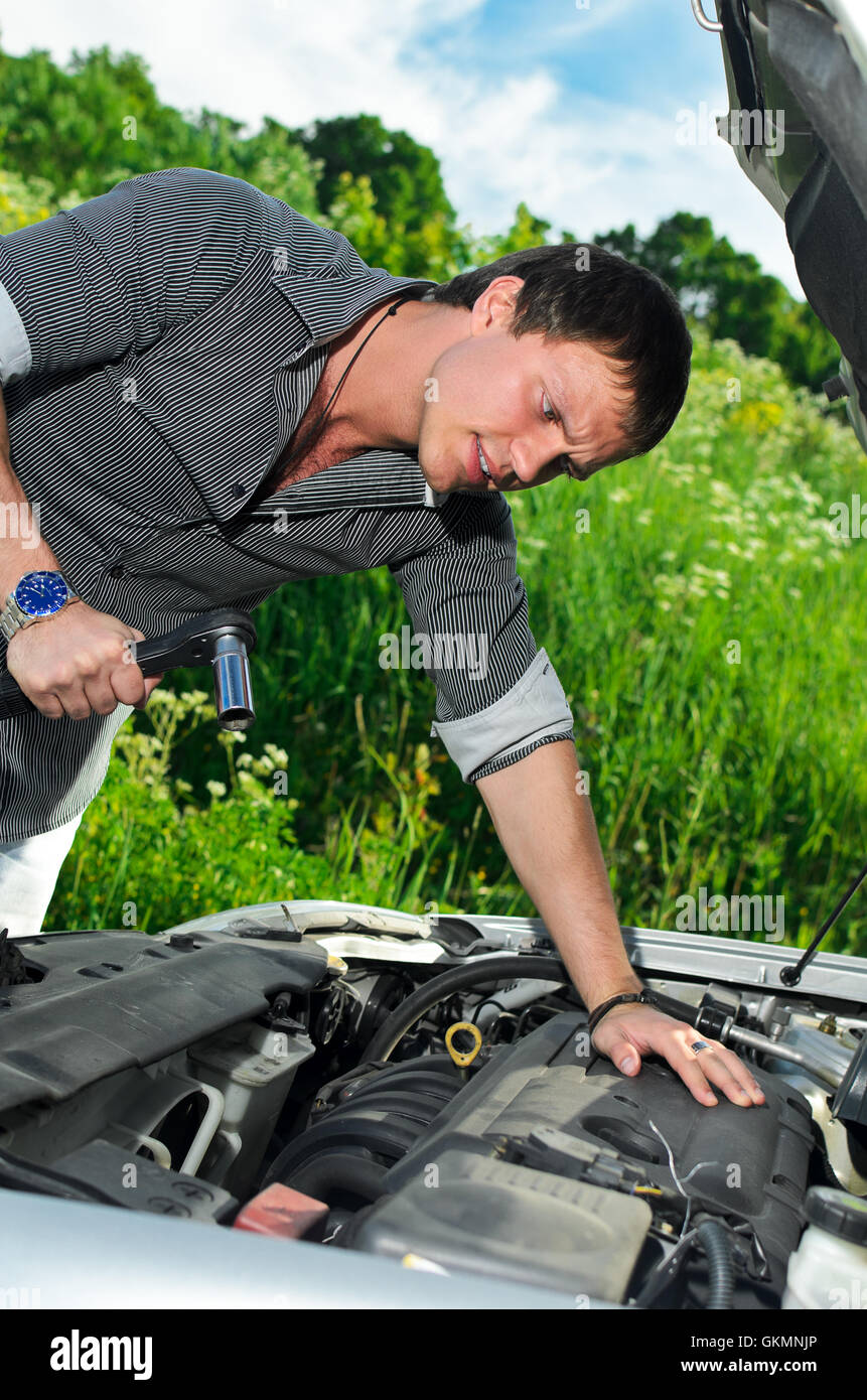 Young man repairing broken car with a socket spanner wrench Stock Photo ...