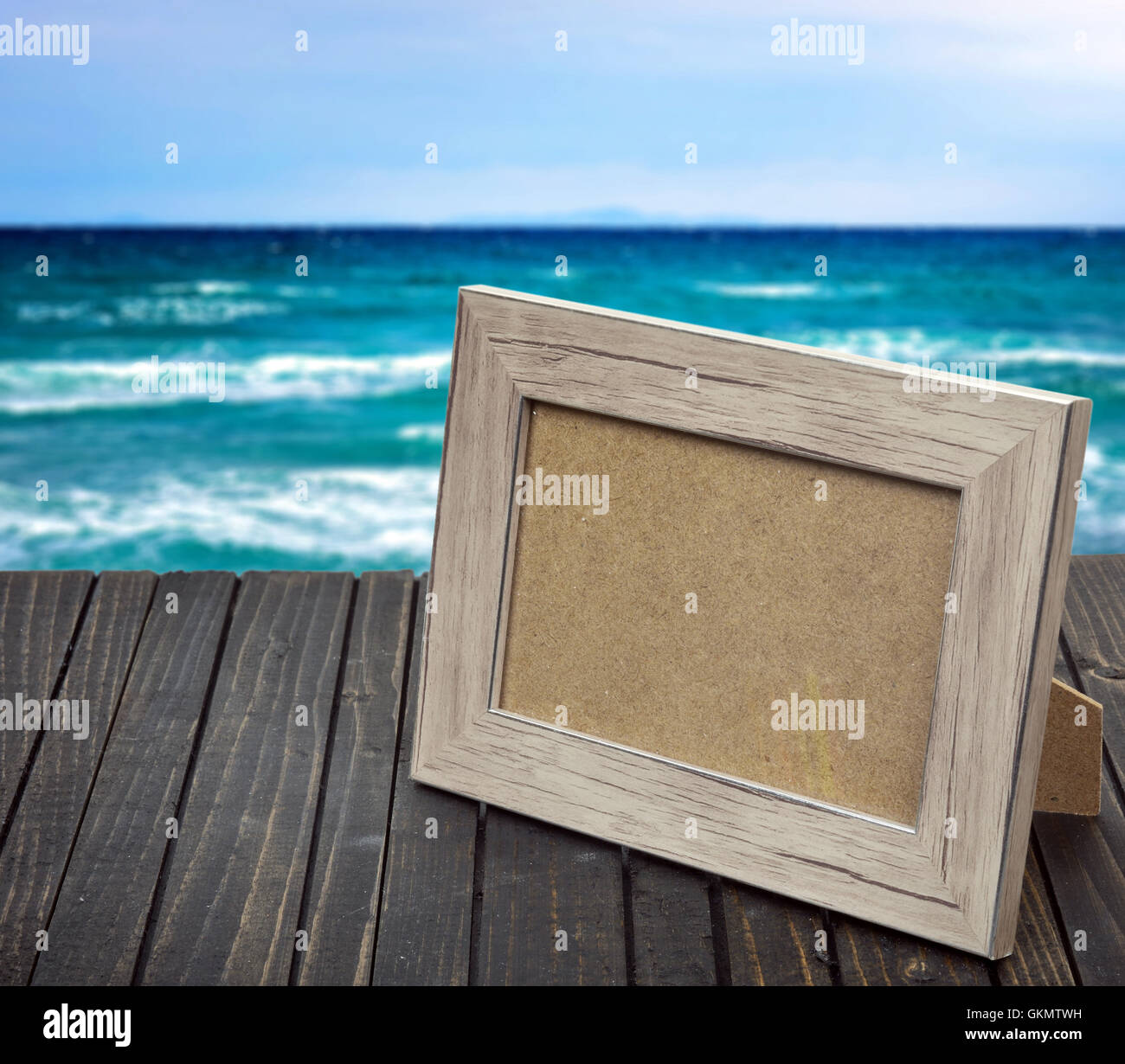 Photo frame on wooden table and sea Stock Photo
