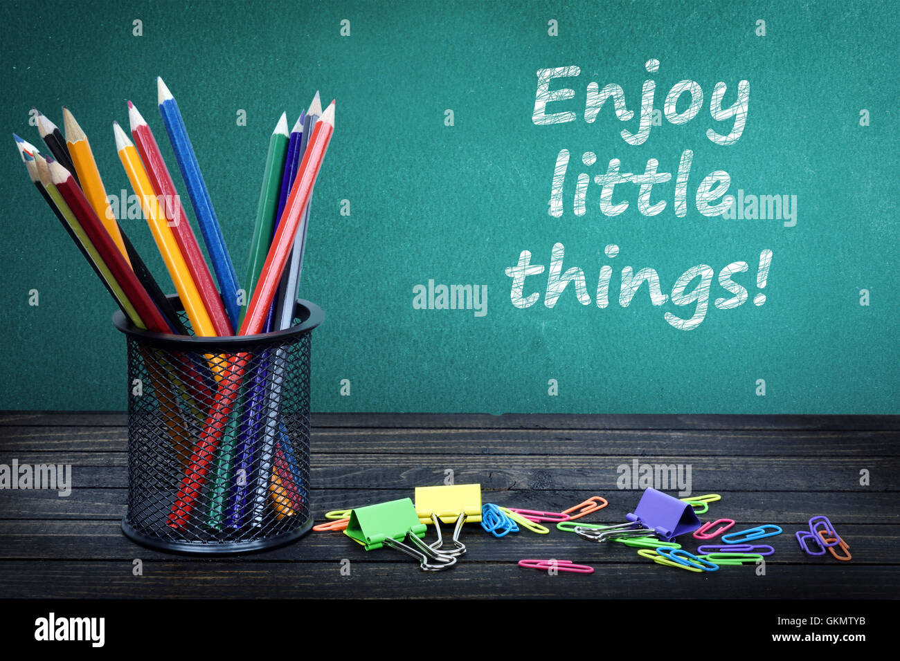 Enjoy little things text on green board and group of pencils Stock Photo
