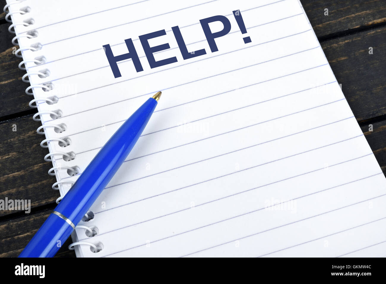 Help text on notepad and blue pen Stock Photo