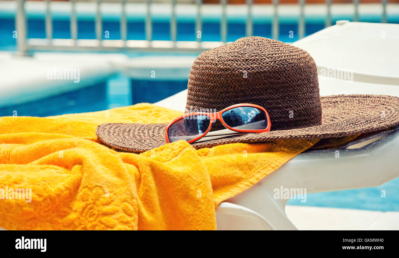 Straw hat with towel near the swimming pool Stock Photo - Alamy