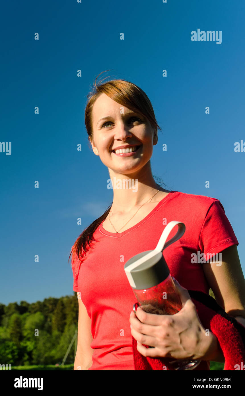 Smiling female runner with bottle of water Stock Photo - Alamy