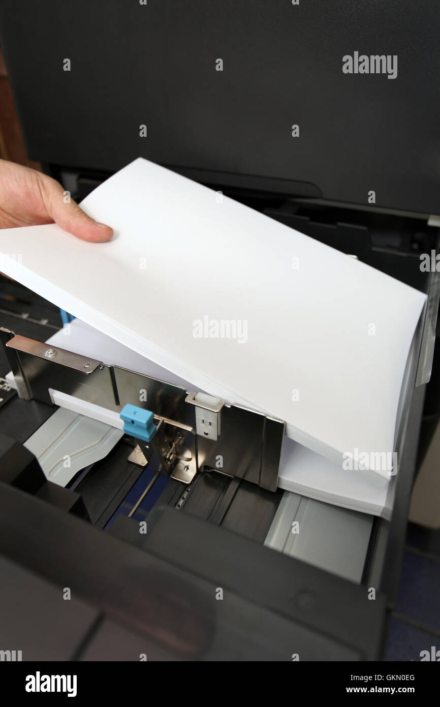 Copier Insert details of hand inserts a paper A4 into a laser copier Stock Photo - Alamy