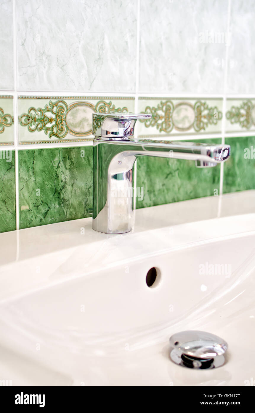 Green interior of bathroom with faucet and sink Stock Photo - Alamy
