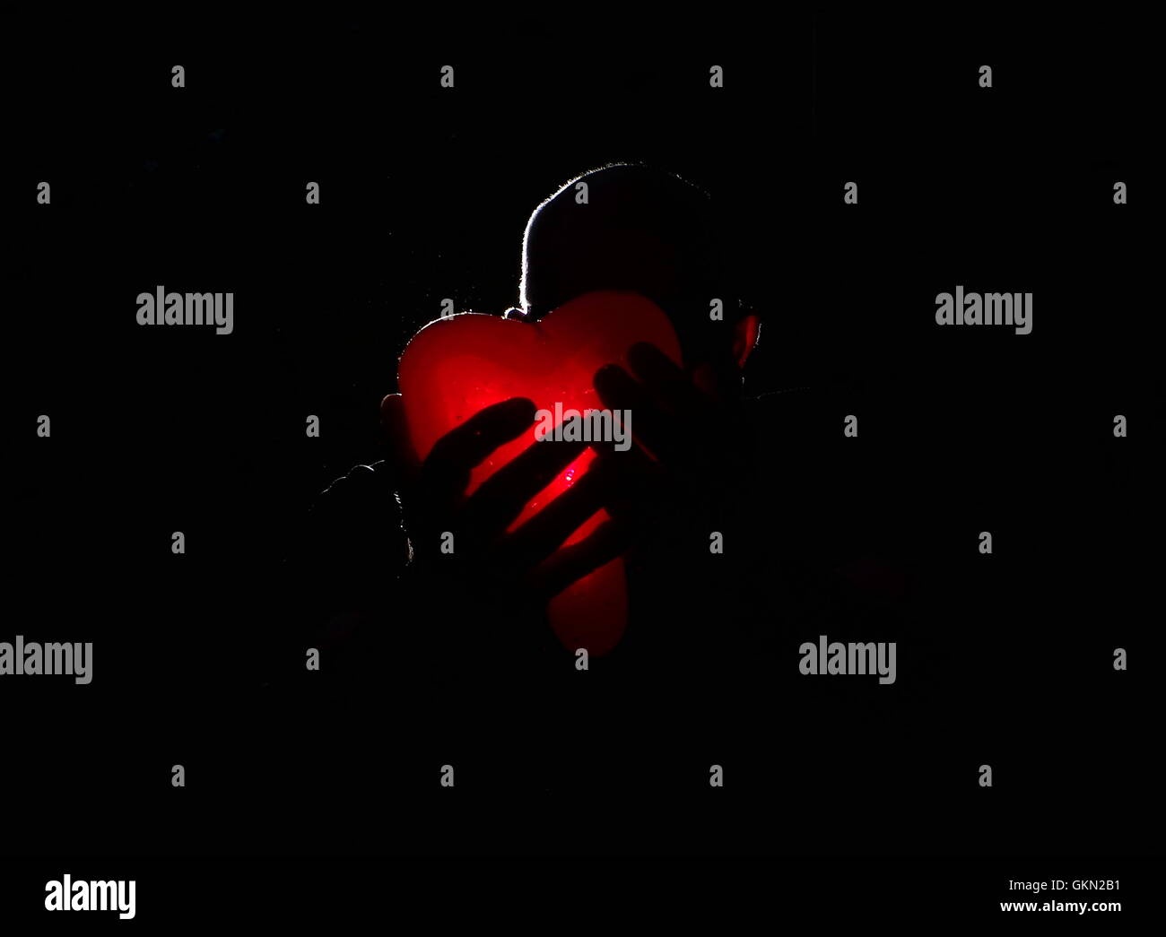 Man holding glowing red heart Stock Photo - Alamy