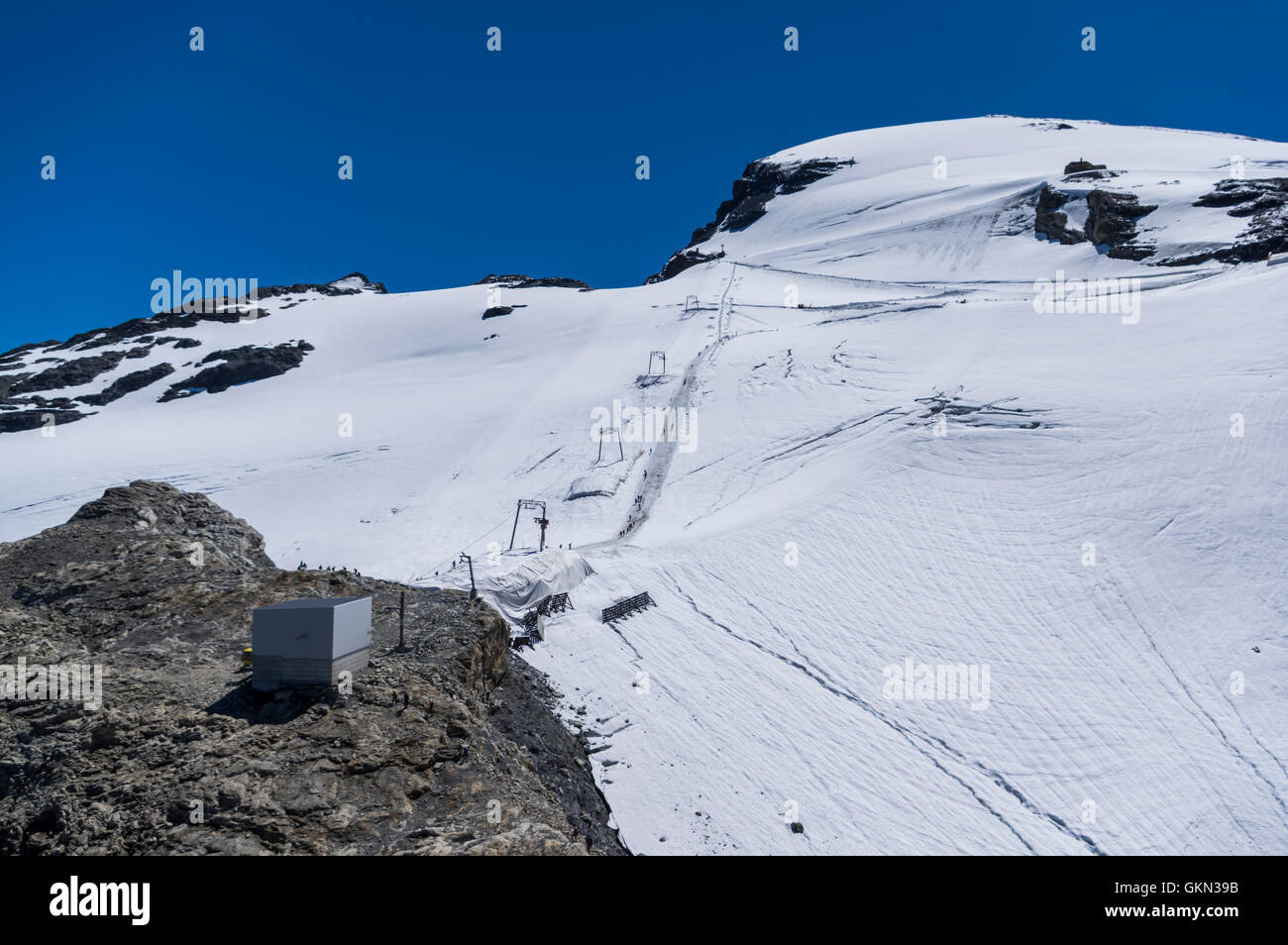 Ski lift on Titlis glacier in summer. White foil close to lift masts placed to slow down glacier melting. Engelberg, Switzerland Stock Photo