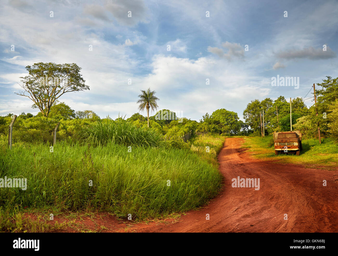 Red soil road and old abandoned truck. Landscape of Parana Misiones Province of Argentina. countryside.  Rural Landscape. Stock Photo