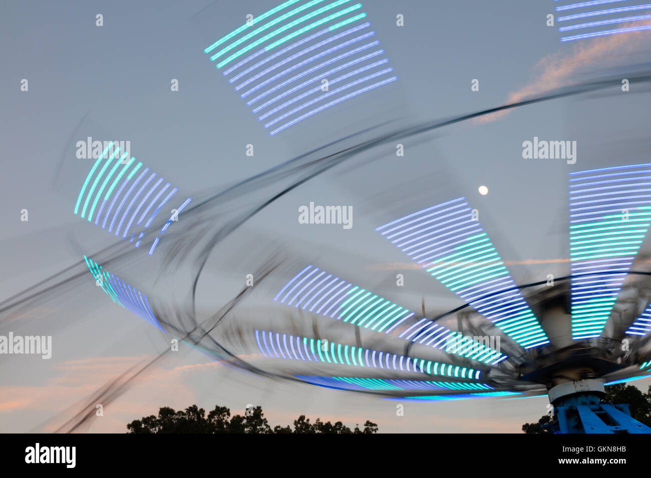 Amusement park ride at a county fair at dusk Stock Photo