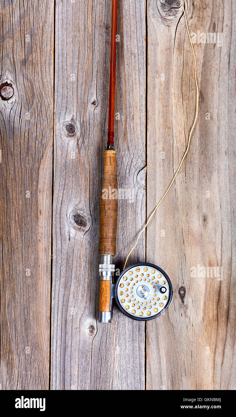 Vintage fly fishing equipment on top of large trout in riverbed