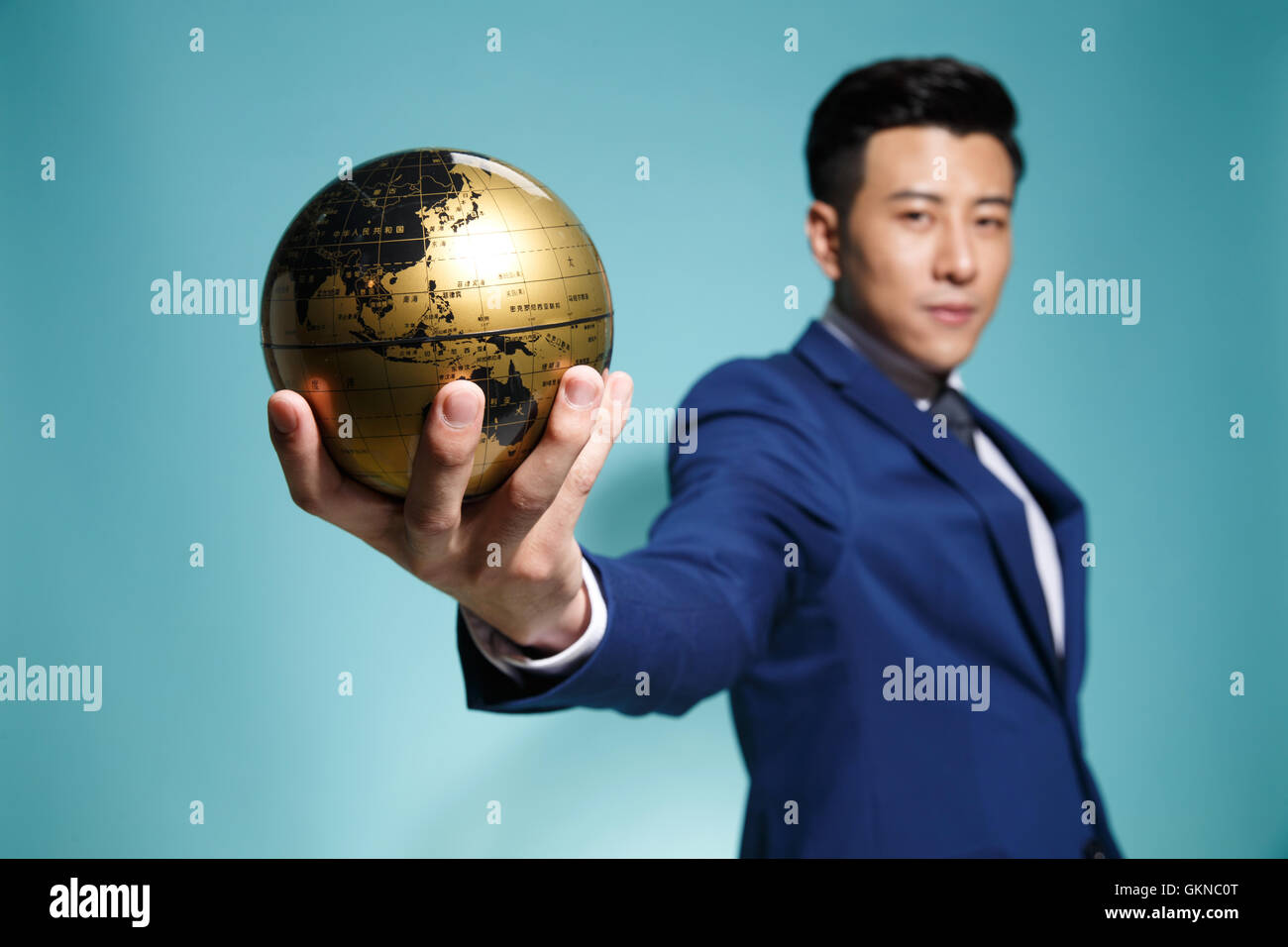 Young business man holding the globe Stock Photo - Alamy
