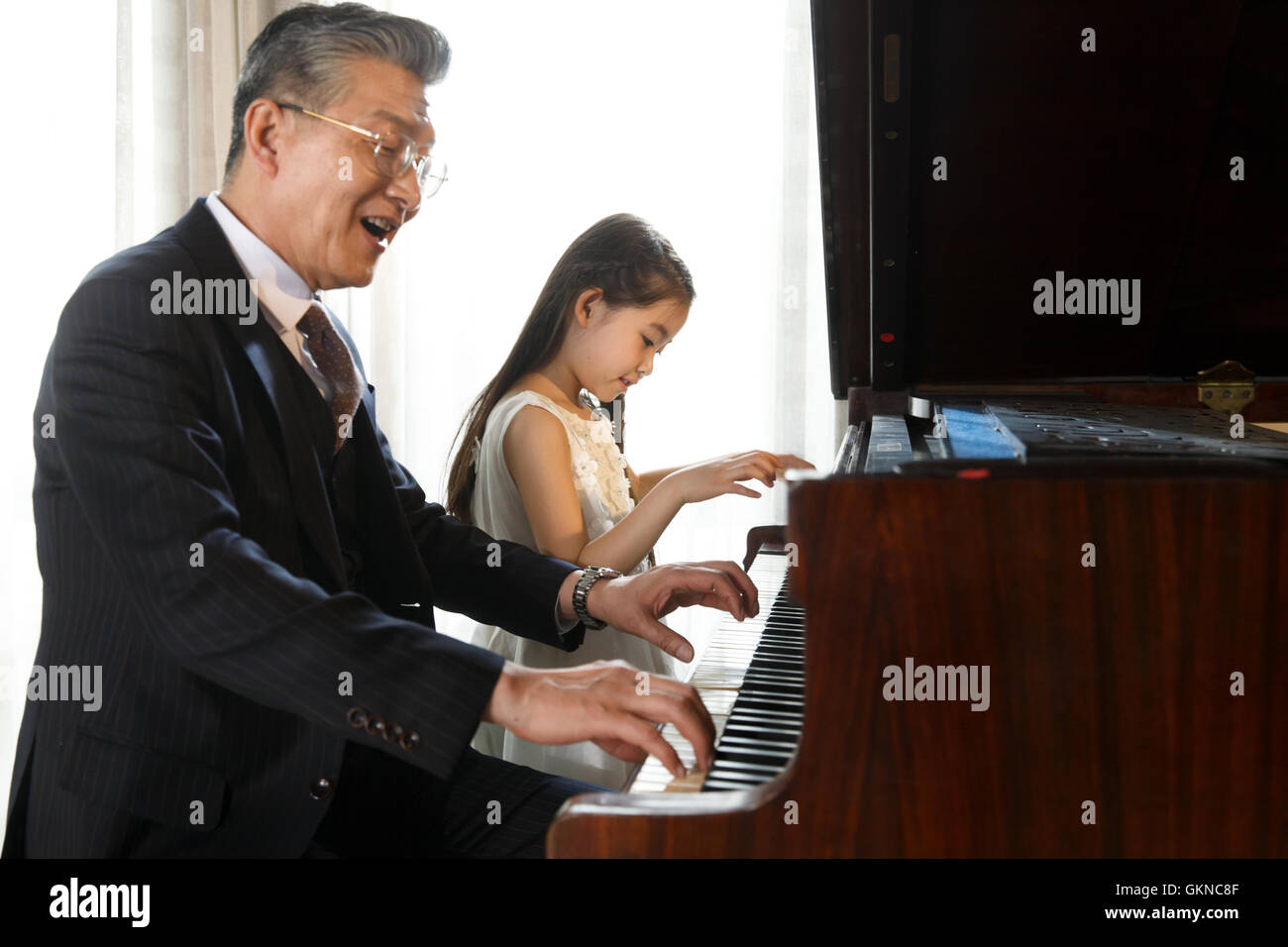 Família Nova Feliz Que Escuta Como Cildren a Música Do Piano Dos Jogos  Imagem de Stock - Imagem de jeans, pessoa: 94440149