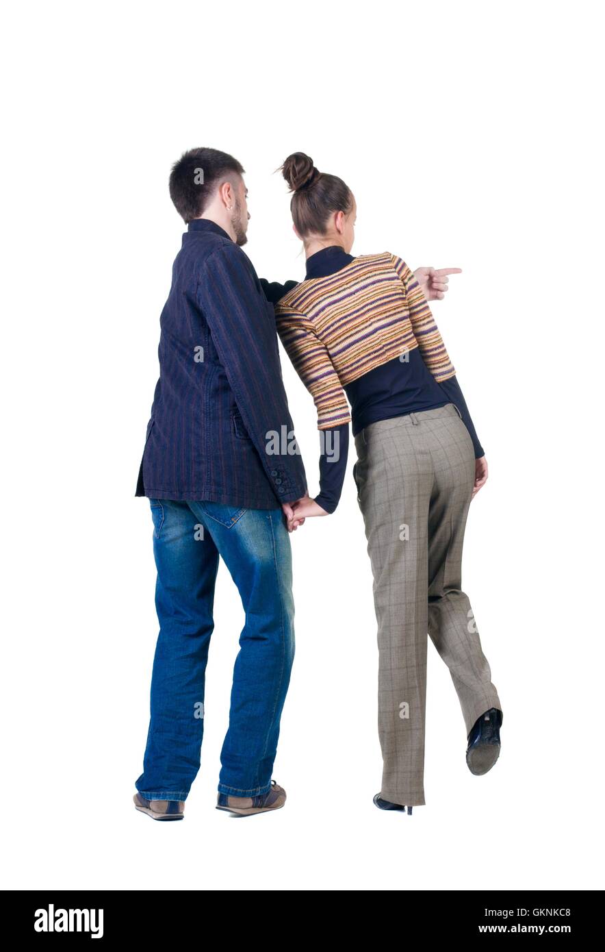 Young couple pointing at wall. Rear view. Stock Photo