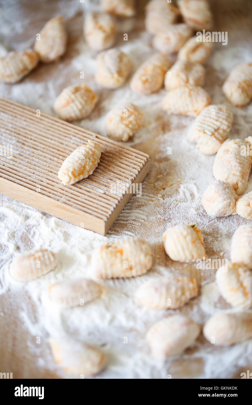Homemade pumpkin gnocchi on a pastry board with a typical comb for pasta Stock Photo Alamy