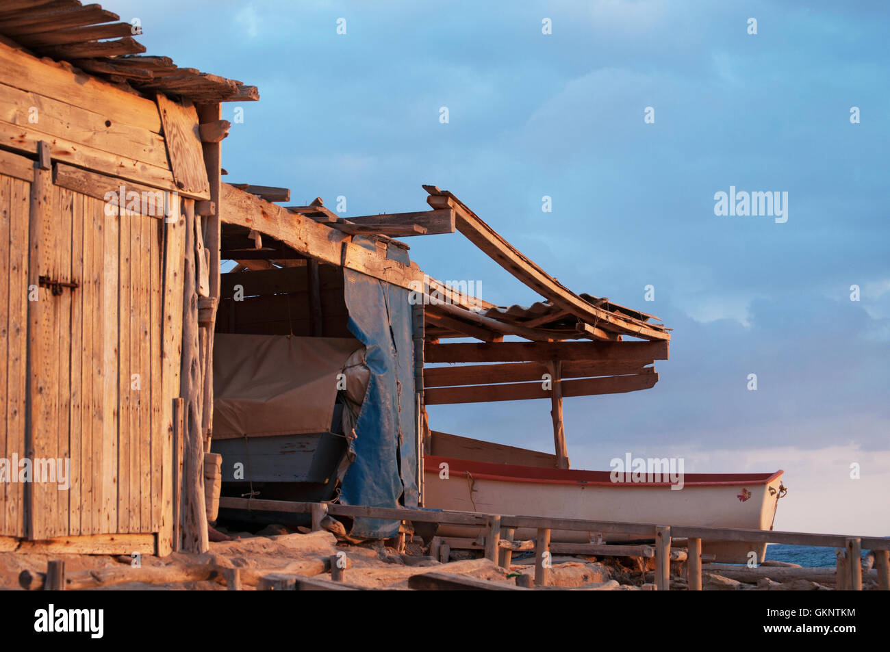 Formentera, Balearic Islands: a boat and a fishermen's cabin at sunset at Calo des Mort, a hidden cove Stock Photo